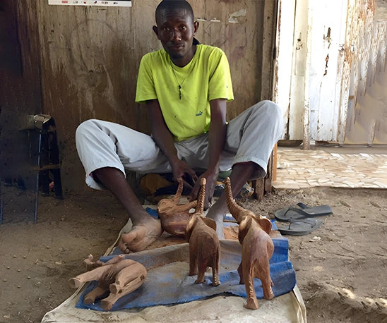 artisan sénégalais sculptant des éléphants en bois artisanat africain fait main atelier Senegal'Art